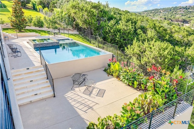 view of swimming pool with a patio area and an in ground hot tub