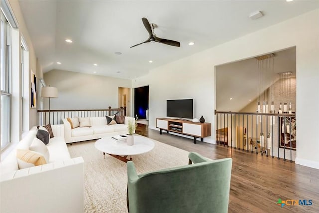 living room featuring ceiling fan and dark hardwood / wood-style floors