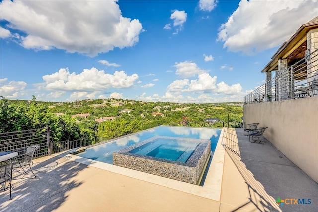 view of pool with an in ground hot tub and a patio