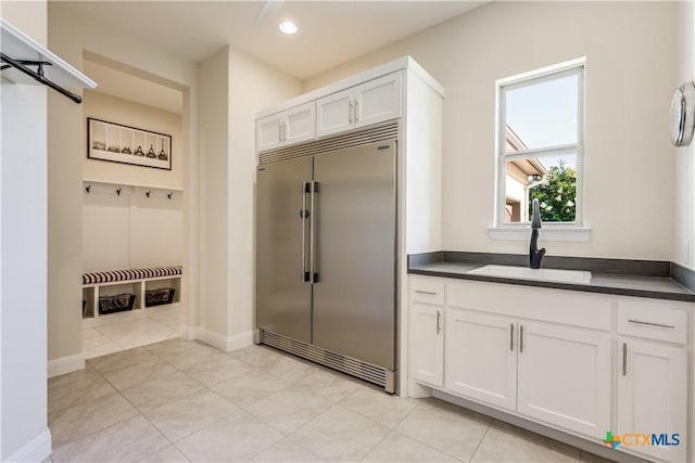 mudroom with light tile patterned floors and sink