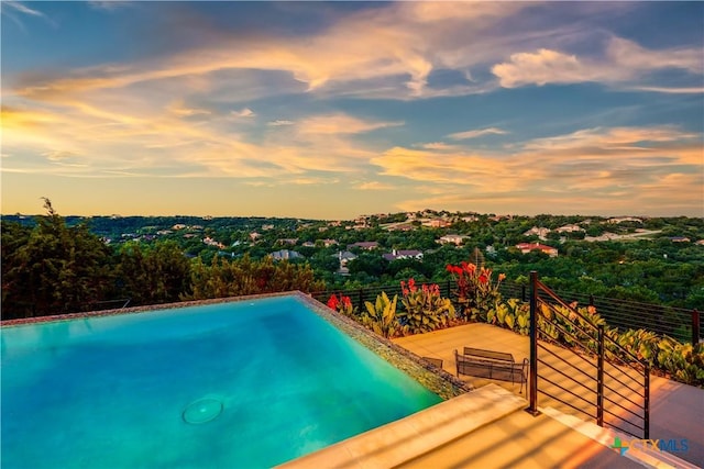 view of pool at dusk