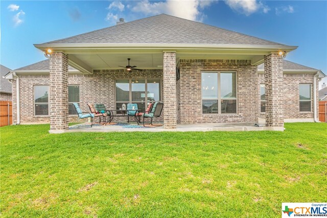 back of property with a patio, a yard, and ceiling fan