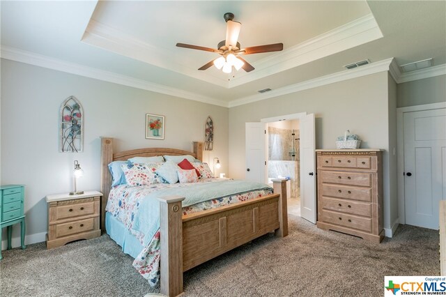 carpeted bedroom featuring connected bathroom, a tray ceiling, ceiling fan, and crown molding