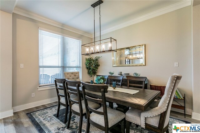 dining space with dark hardwood / wood-style flooring, crown molding, and plenty of natural light