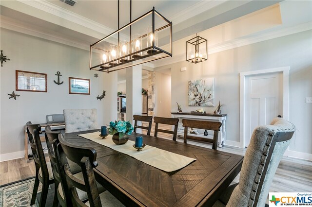 dining area featuring ornamental molding and wood-type flooring