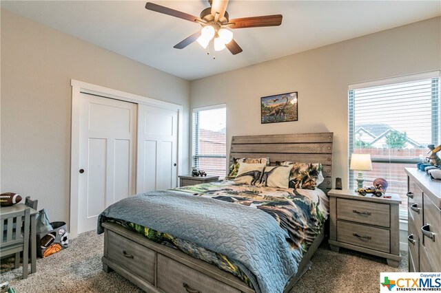 bedroom featuring ceiling fan and dark carpet