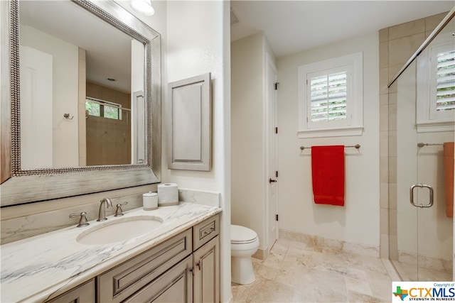 bathroom featuring toilet, vanity, and an enclosed shower