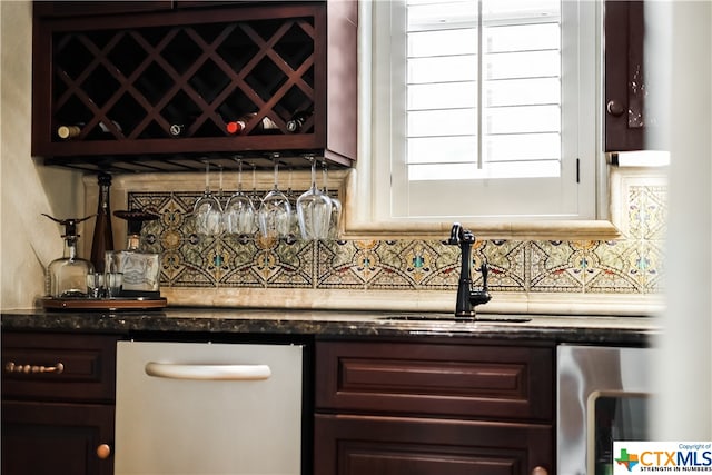 bar featuring dishwasher, tasteful backsplash, sink, and dark brown cabinetry