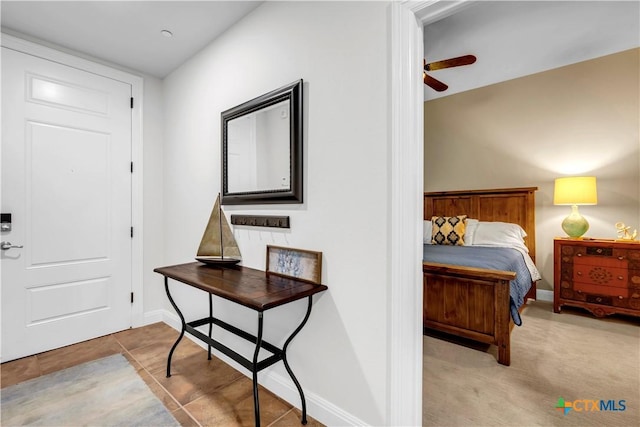 foyer featuring ceiling fan and light colored carpet