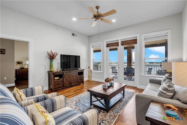 living room with ceiling fan, a healthy amount of sunlight, and light hardwood / wood-style floors