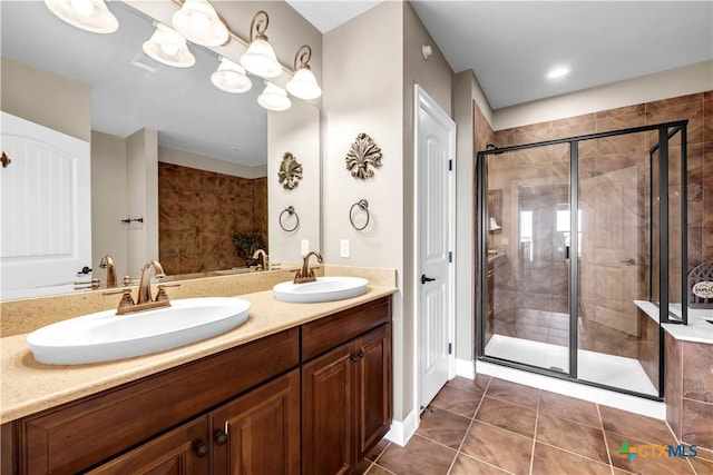 bathroom featuring tile patterned flooring, vanity, and walk in shower