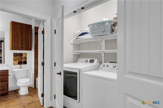 laundry area featuring washing machine and dryer and light tile patterned flooring