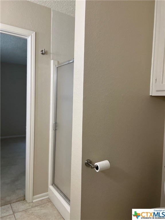 bathroom featuring tile patterned floors, a textured ceiling, and walk in shower