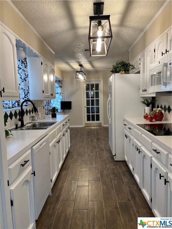 kitchen with white cabinetry, decorative light fixtures, and white appliances