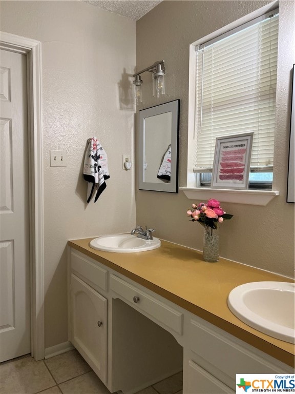 bathroom with tile patterned flooring, vanity, and a textured ceiling