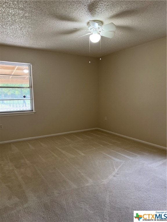 carpeted spare room with ceiling fan and a textured ceiling