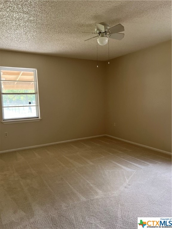 carpeted spare room with ceiling fan and a textured ceiling