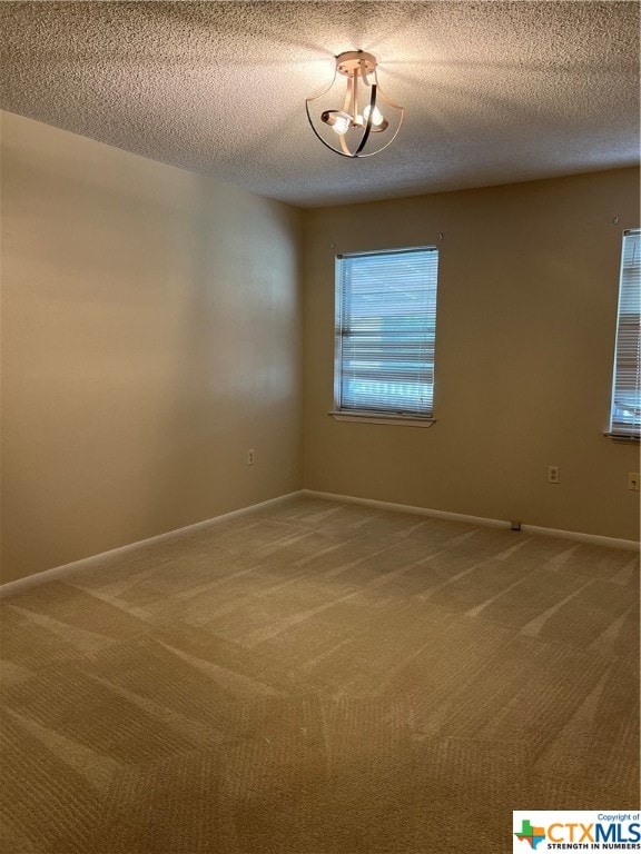 unfurnished room featuring carpet flooring and a textured ceiling