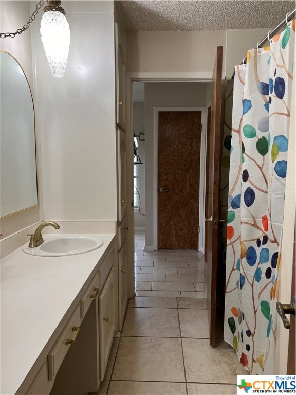 bathroom featuring vanity, a textured ceiling, and tile patterned floors