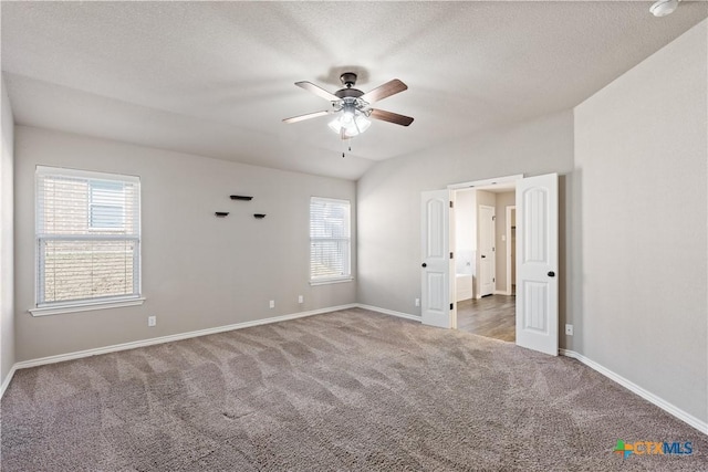 empty room featuring carpet floors, plenty of natural light, a ceiling fan, and baseboards