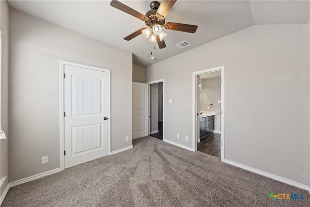 unfurnished bedroom with ensuite bathroom, carpet flooring, visible vents, baseboards, and vaulted ceiling