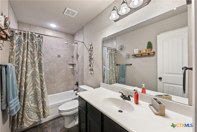 bathroom with visible vents, toilet, wood finished floors, a textured ceiling, and vanity