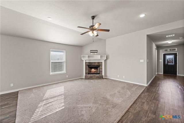 unfurnished living room with baseboards, visible vents, a ceiling fan, lofted ceiling, and a fireplace