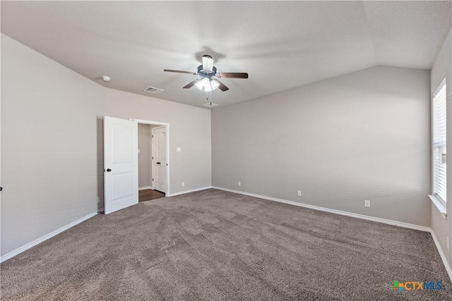 empty room featuring carpet floors, visible vents, a ceiling fan, vaulted ceiling, and baseboards