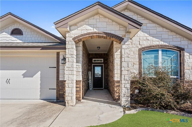 view of exterior entry with stone siding, a shingled roof, and an attached garage