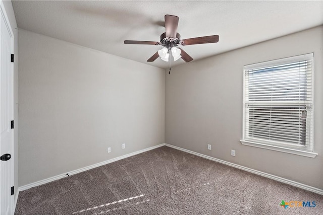 carpeted empty room featuring a ceiling fan and baseboards