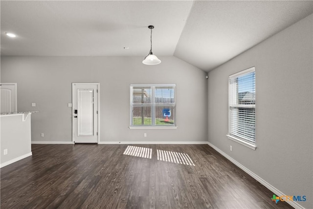 unfurnished room featuring lofted ceiling, dark wood finished floors, and baseboards