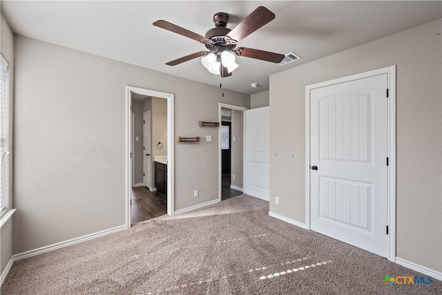 unfurnished bedroom featuring ensuite bathroom, carpet flooring, visible vents, and baseboards