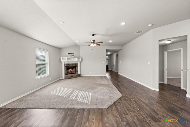 unfurnished living room with visible vents, a fireplace, baseboards, and wood finished floors