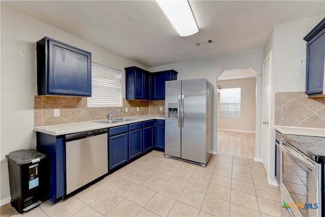 kitchen with blue cabinetry, sink, and appliances with stainless steel finishes