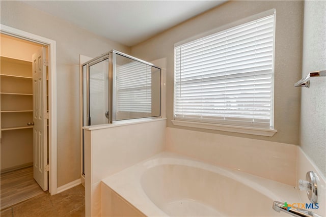 bathroom with shower with separate bathtub and tile patterned floors