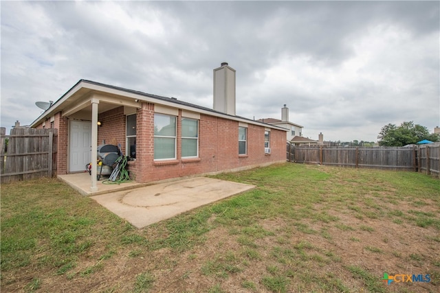 back of house featuring a patio and a yard