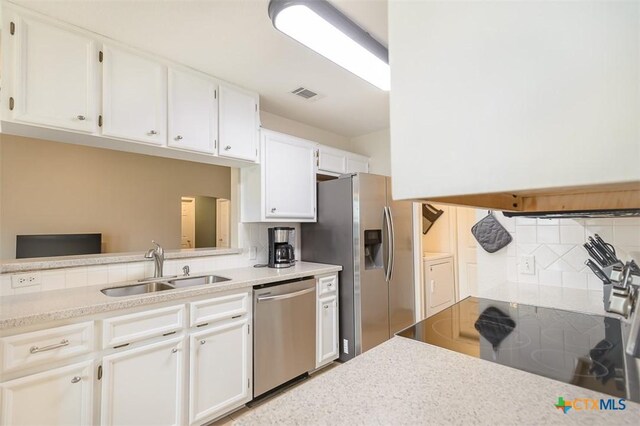 4413 Pete Dr, Killeen, TX 76549 - kitchen with stainless steel appliances, a sink, decorative backsplash, and white cabinetry