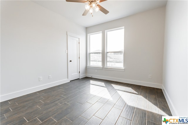 empty room with dark hardwood / wood-style flooring and ceiling fan