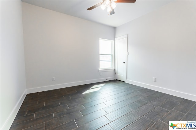 spare room with dark hardwood / wood-style flooring and ceiling fan