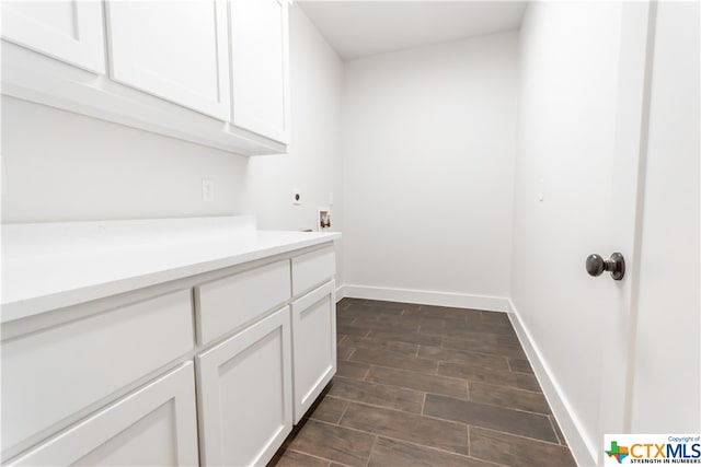 clothes washing area with cabinets, dark wood-type flooring, electric dryer hookup, and washer hookup