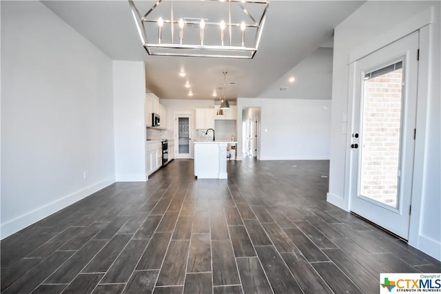 8500 Kasen Ave, Killeen, TX 76542 - unfurnished living room with dark wood finished floors, a sink, baseboards, and a chandelier
