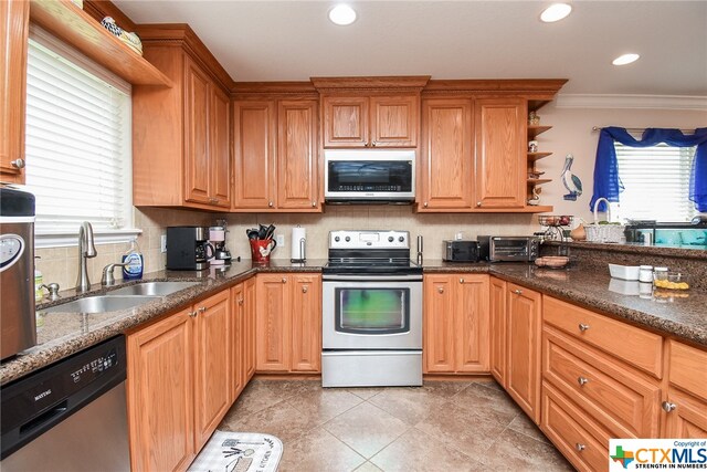 kitchen featuring sink, appliances with stainless steel finishes, tasteful backsplash, dark stone counters, and crown molding