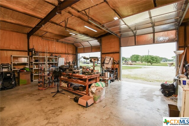 garage with wooden walls and a workshop area