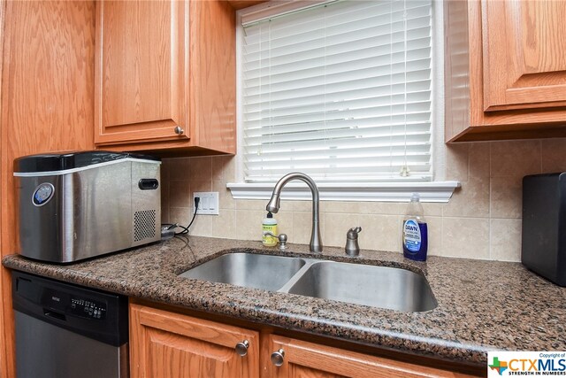 kitchen with dishwasher, tasteful backsplash, sink, and dark stone countertops