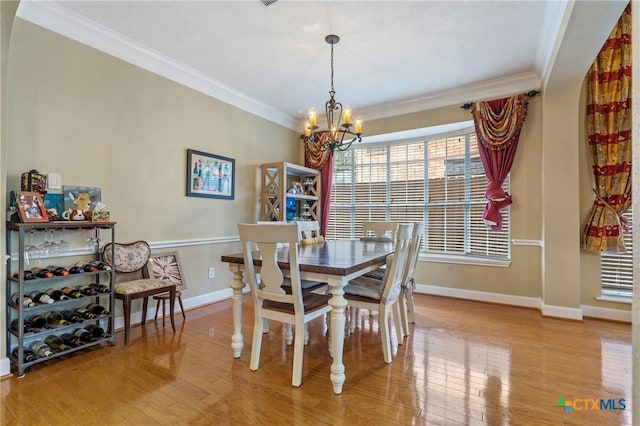 dining room with crown molding, a chandelier, and light hardwood / wood-style floors