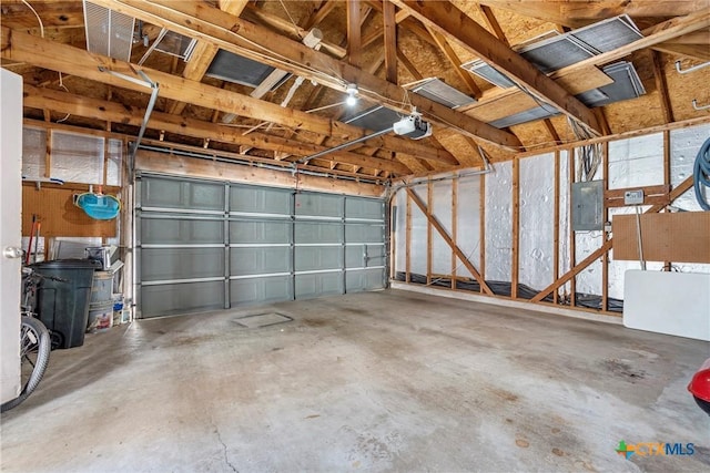 garage with electric panel and a garage door opener