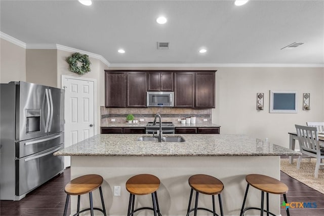 3312 Shawlands Rd, Killeen, TX 76542 - kitchen with appliances with stainless steel finishes, dark wood-type flooring, dark brown cabinets, ornamental molding, and backsplash