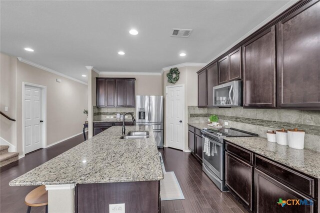 3312 Shawlands Rd, Killeen, TX 76542 - kitchen featuring appliances with stainless steel finishes, crown molding, tasteful backsplash, light stone countertops, and dark brown cabinetry