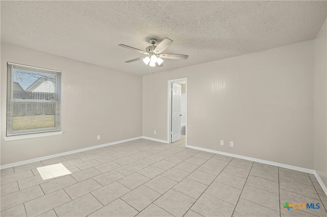 spare room featuring ceiling fan, a textured ceiling, and baseboards