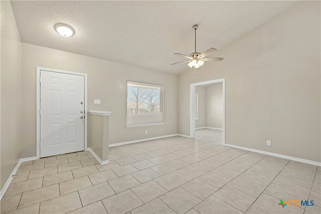 entryway with lofted ceiling, light tile patterned flooring, ceiling fan, a textured ceiling, and baseboards